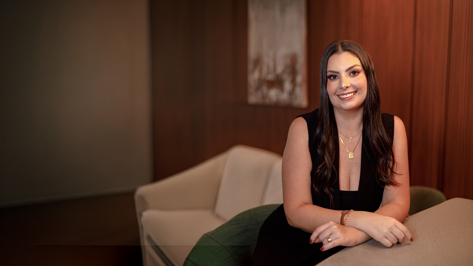 Paula Vilhena, advogada, sentada em um sofá em seu escritório